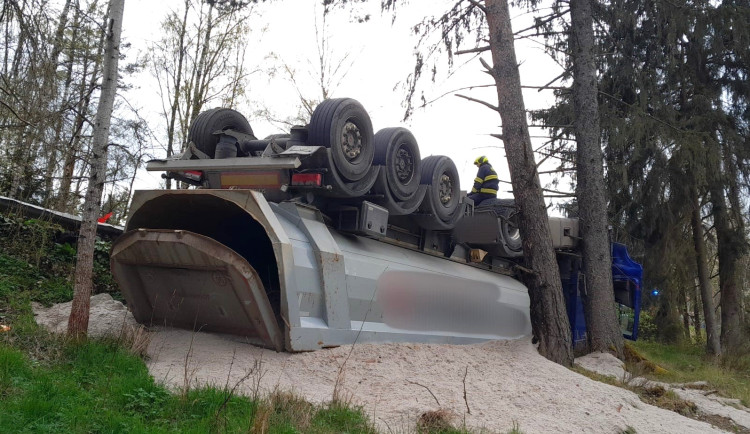 Náklaďák s pískem skončil na střeše a řidič v nemocnici, zranění utrpěla i žena, jejíž auto rozmáčkl spadlý strom