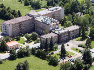 Kácení dřevin a demolice starých garáží. V areálu Rokycanské nemocnice se pohybují dělníci