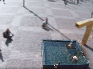 Polonahý muž za bílého dne lovil mince z kašny na náměstí. Na chodce vystrkoval téměř holé pozadí