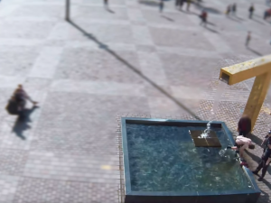 Polonahý muž za bílého dne lovil mince z kašny na náměstí. Na chodce vystrkoval téměř holé pozadí