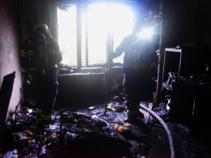 Uvnitř vyhořelého bytu objevili hasiči mrtvého muže. Ženu, která z bytu ujela, našli později mrtvou u auta