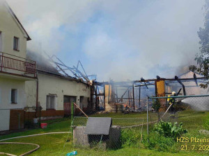 Na Domažlicku hoří hromada pneumatik a okolní budovy, ve vedru kolabují hasiči