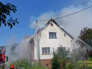 Na Domažlicku hoří hromada pneumatik a okolní budovy, ve vedru kolabují hasiči