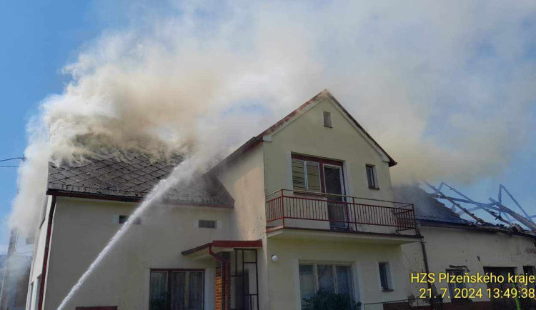 Na Domažlicku hoří hromada pneumatik a okolní budovy, ve vedru kolabují hasiči
