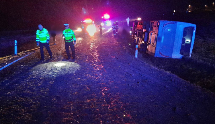 Autobus se převrátil na bok do příkopu. Dostal smyk na silnici, kterou silně znečistila vrstv kluzkého bahna