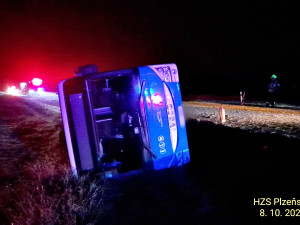 Autobus se převrátil na bok do příkopu. Dostal smyk na silnici, kterou silně znečistila vrstv kluzkého bahna