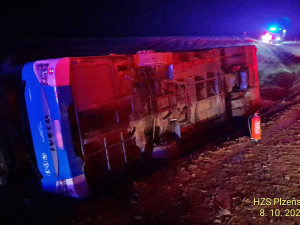 Autobus se převrátil na bok do příkopu. Dostal smyk na silnici, kterou silně znečistila vrstv kluzkého bahna
