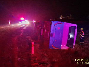 Autobus se převrátil na bok do příkopu. Dostal smyk na silnici, kterou silně znečistila vrstv kluzkého bahna