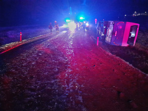 Autobus se převrátil na bok do příkopu. Dostal smyk na silnici, kterou silně znečistila vrstv kluzkého bahna