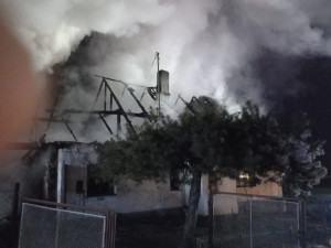 Hasiči bojují s požárem rodinného domu, snaží se uchránit před plameny sousední penzion