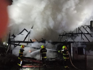 Hasiči bojují s požárem rodinného domu, snaží se uchránit před plameny sousední penzion