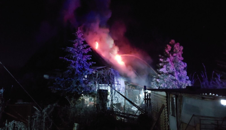 Hasiči bojují s požárem rodinného domu, snaží se uchránit před plameny sousední penzion