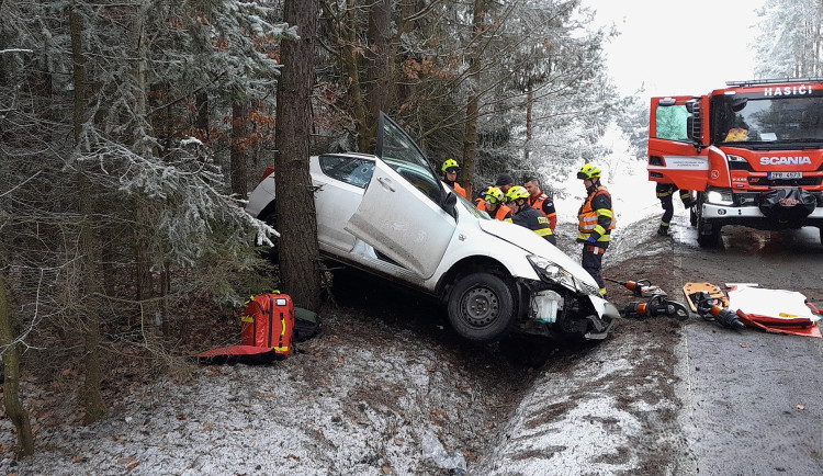 Ženu a malé dítě museli hasiči vyprostit z havarovaného auta, řidička dostala smyk a narazila do čtyř stromů