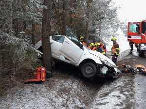 Ženu a malé dítě museli hasiči vyprostit z havarovaného auta, řidička dostala smyk a narazila do čtyř stromů