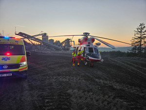 Převrácená sklápěčka uvěznila těžce zraněného řidiče, v lomu přistával záchranářský vrtulník