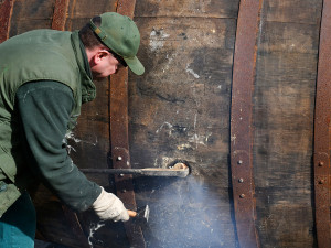 Nebezpečná dřina, zruční bednáři slavného pivovaru začali smolit 20 obřích ležáckých sudů tradiční metodou