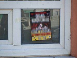 Černý výlep plakátů s reklamou na cirkus. Ženy polepily vše, kde držela lepenka