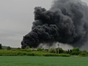 Hasiči bojují s rozsáhlým požárem pneumatik, černý kouř je vidět na kilometry daleko