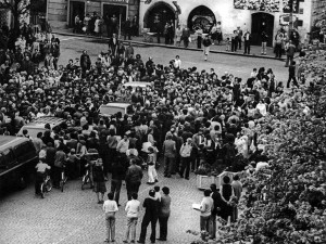 Tajně pořízená fotografie Milanem Pokorným z věže dnešní radnice v Sušici v roce 1986. Zachycuje nepovolené shromáždění občanů po příjezdu delegace z amerického velvyslanectví