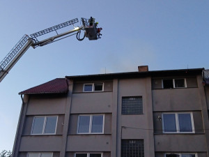 Při požáru bytovky se zranili dva hasiči a obyvatel domu, škoda je přes milion