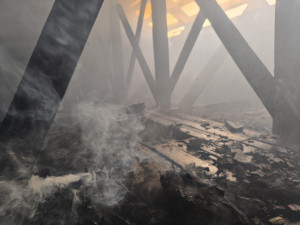 Při požáru bytovky se zranili dva hasiči a obyvatel domu, škoda je přes milion