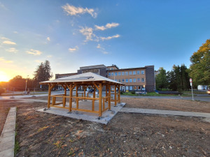 Nevzhledná travnatá plocha před nemocnicí se mění v park s altánem