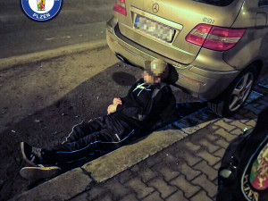 Opilý muž vyděsil kolemjdoucí, zalezl si pod zaparkované auto a zasekl se tam