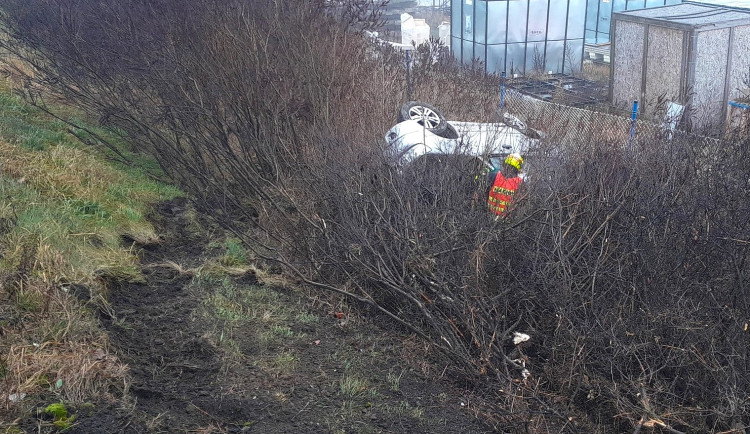 Auto se zřítilo ze strmého svahu a skončilo převrácené v křoví hluboko pod tělesem dálnice