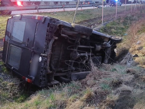 Mikrobus po střetu s osobákem vyletěl z dálnice, prorazil oplocení a skončil na boku