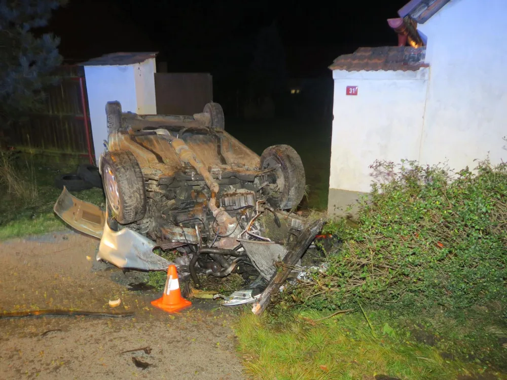 Auto zbořilo hradbu a přistálo na střeše ve vjezdu dalšího domu, řidič od nehody ujel jiným vozem