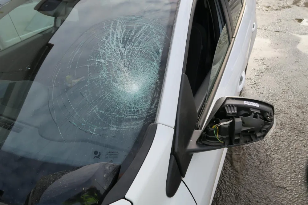 Při pádu popelář poškodil čelní sklo a zpětné zrcátko osobního automobilu