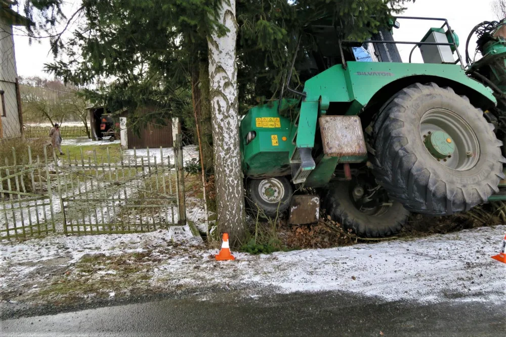 Po smyku na kluzké vozovce ukončil těžký stavební stroj svoji jízdu nárazem do stromů