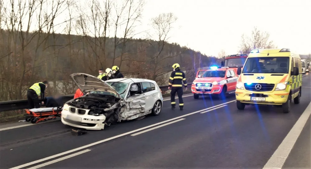 Řidič BMW přejel do protisměru a srazil se s náklaďákem převážejícím stavební stroj