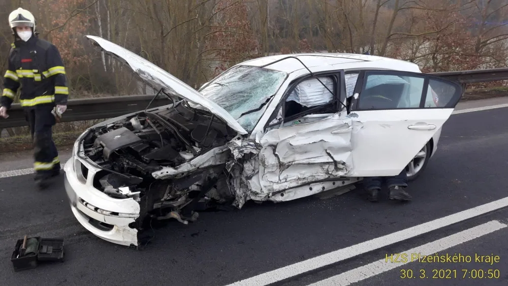 Řidič BMW přejel do protisměru a srazil se s náklaďákem převážejícím stavební stroj