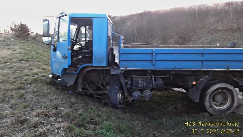 Řidič BMW přejel do protisměru a srazil se s náklaďákem převážejícím stavební stroj