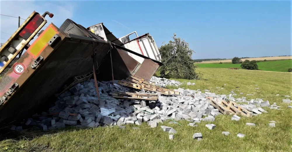 Auto najelo na nezpevněnou krajnici a zřítilo se za svahu, naložený stavební materiál se vsypal