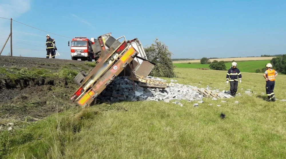 Auto najelo na nezpevněnou krajnici a zřítilo se za svahu, naložený stavební materiál se vsypal