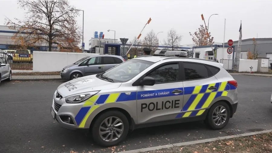 Policisté na místě tragické střelby. V pozadí je vůz, ve které seděla oběť