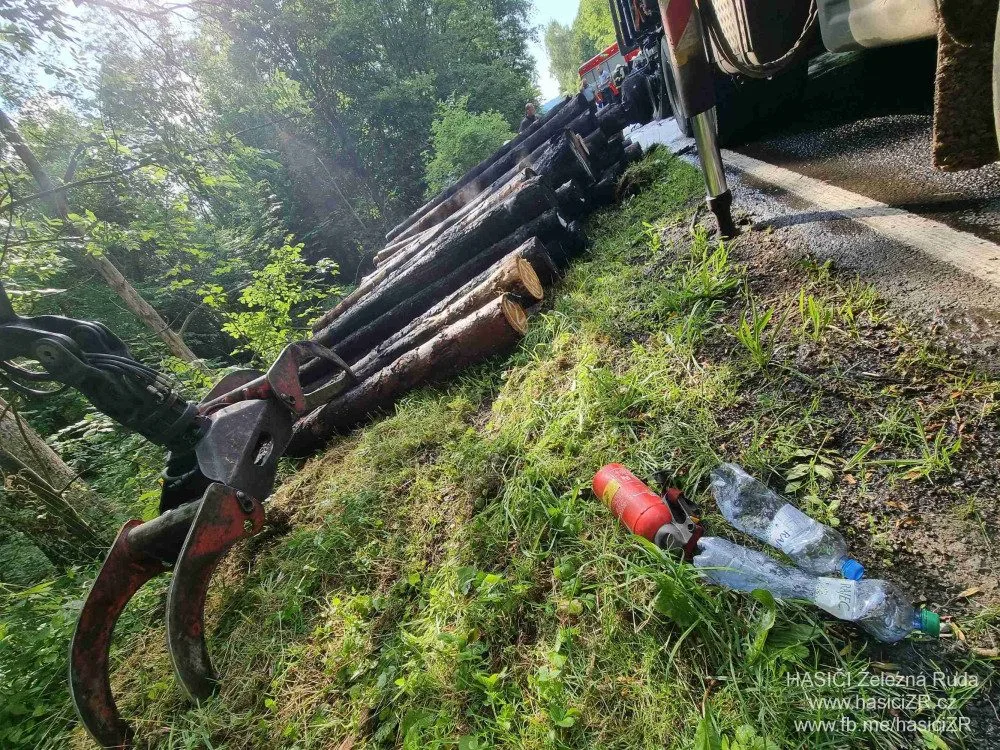 Kamion s nákladem dřeva náhle vzplál, statečný řidič dokázal hydraulickou rukou vyložit většinu hořících klád