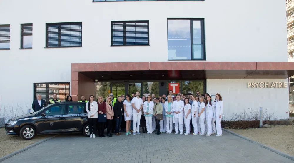 Zaměstnanci Psychiatrické kliniky s kolegy a spolupracovníky před novou budovou.