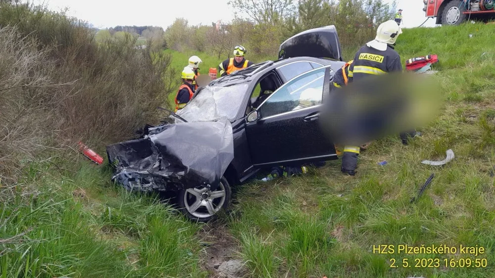 Při hrozivém čelním střetu luxusního mercedesu s nákladním vozidlem pro přepravu dřeva se těžce zranili dva lidé