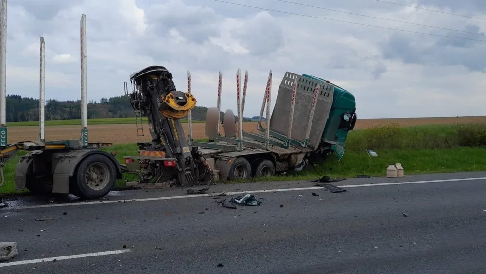 Při hrozivém čelním střetu luxusního mercedesu s nákladním vozidlem pro přepravu dřeva se těžce zranili dva lidé