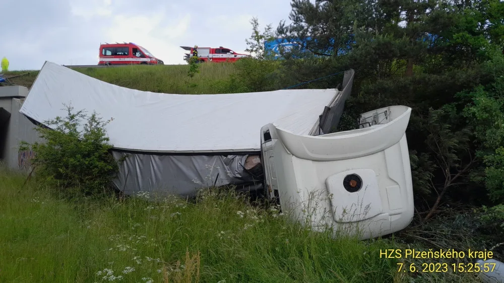 Kamion se zřítil z prudkého srázu po střetu s osobním automobilem odstaveným na okraji dálnice D5