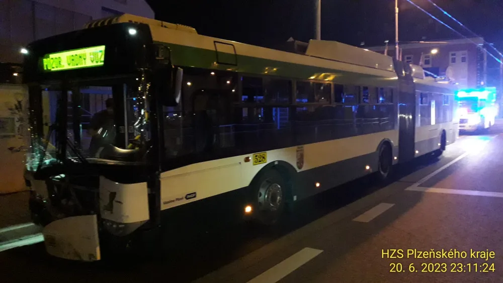 Trolejbus po střetu odmrštil osobní automobil přes chodník a zábradlí až na zeď s billboardem. Dva lidé se zranili