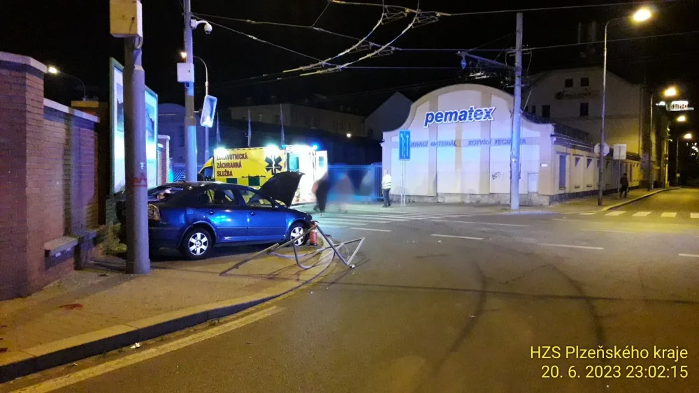 Trolejbus po střetu odmrštil osobní automobil přes chodník a zábradlí až na zeď s billboardem. Dva lidé se zranili