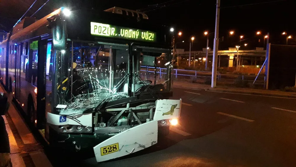 Trolejbus po střetu odmrštil osobní automobil přes chodník a zábradlí až na zeď s billboardem. Dva lidé se zranili