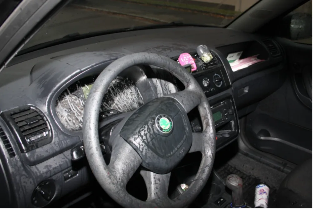 Následky útoku kyselinou v interiéru automobilu