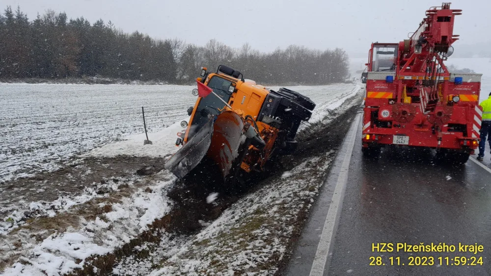 Převrácený sypač i celá řada dalších nehod. Tak vypadá úterý na zasněžených silnicích v Plzeňském kraji