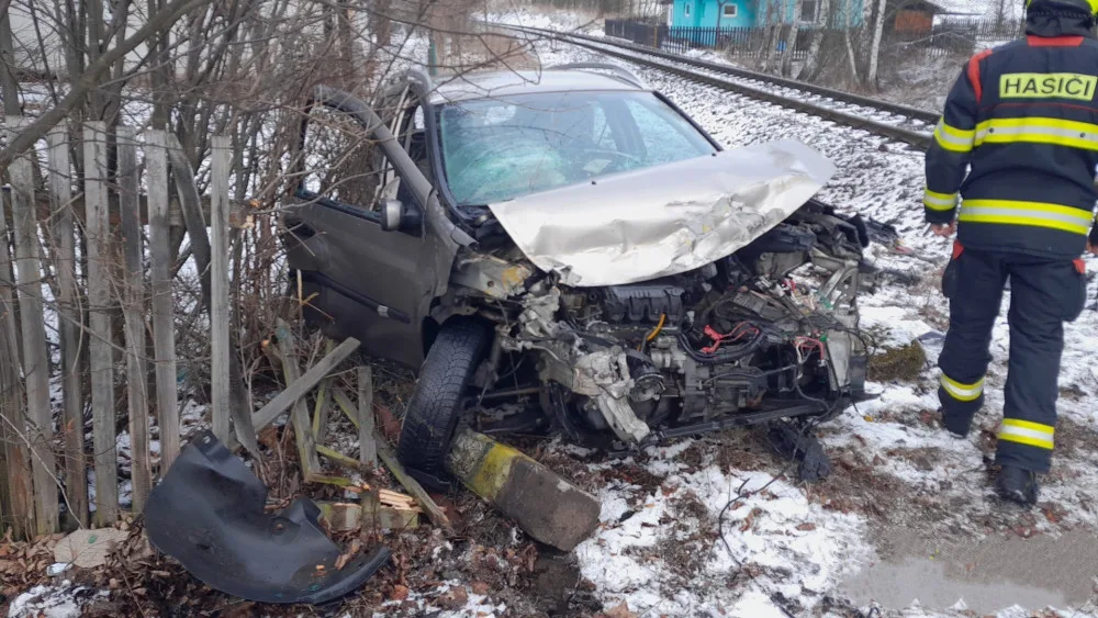Vlak smetl na železničním přejezdu osobní automobil. Náraz odmrštil zdemolovaný vůz až na plot zahrady
