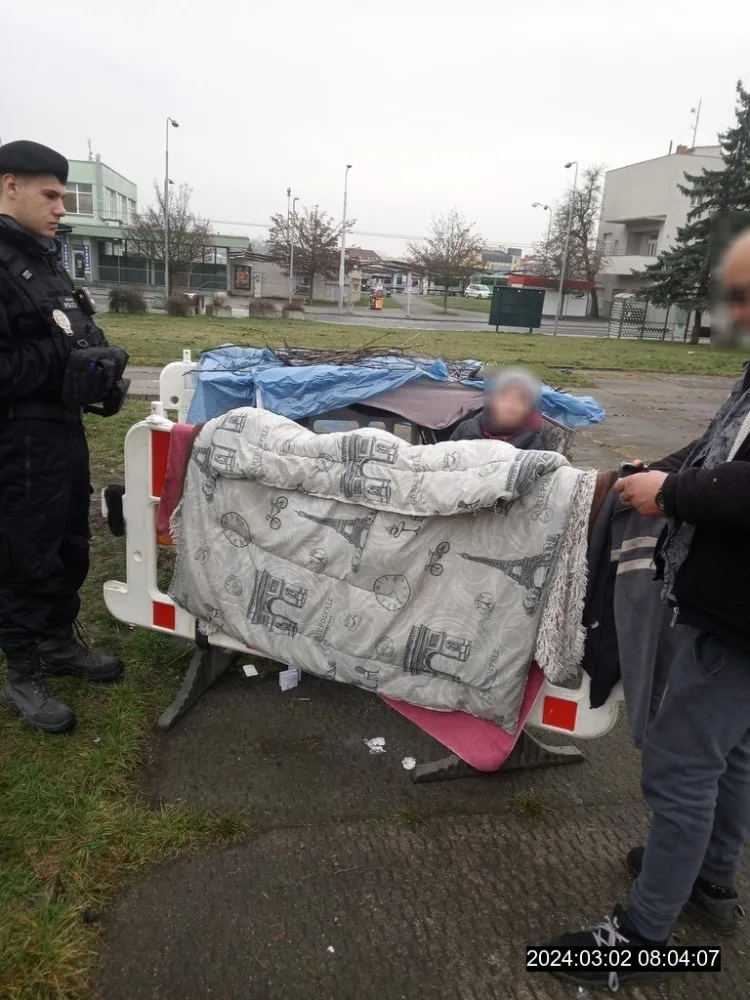 Dva bezdomovci si postavili ležení z bezpečnostních zábran na náměstí, sušili tam prádlo a rozdělávali oheň